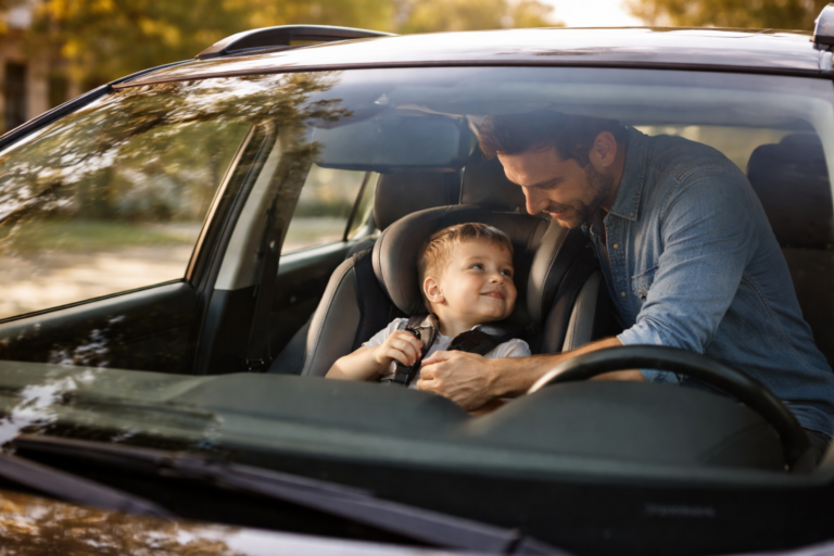 Father securing child in car seat